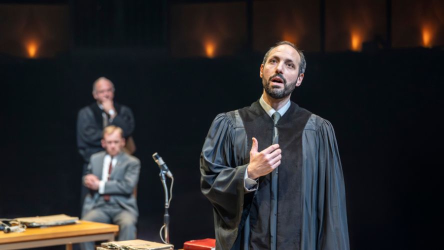 Phillip Arditti plays Fiedler wearing a black gown