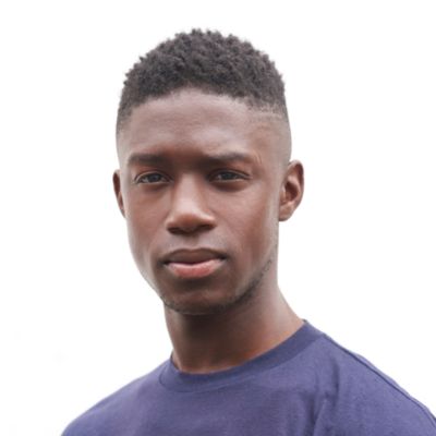 Emeka Sesay in a blue T-shirt with a white background behind him