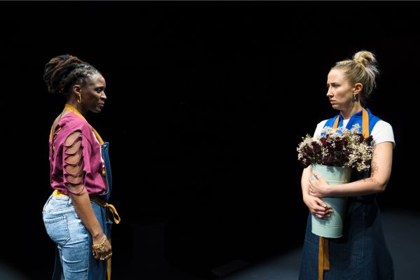 Denise (played by Sharon Duncan Brewster) stands opposite Carly (played by Erin Doherty) who is holding flowers